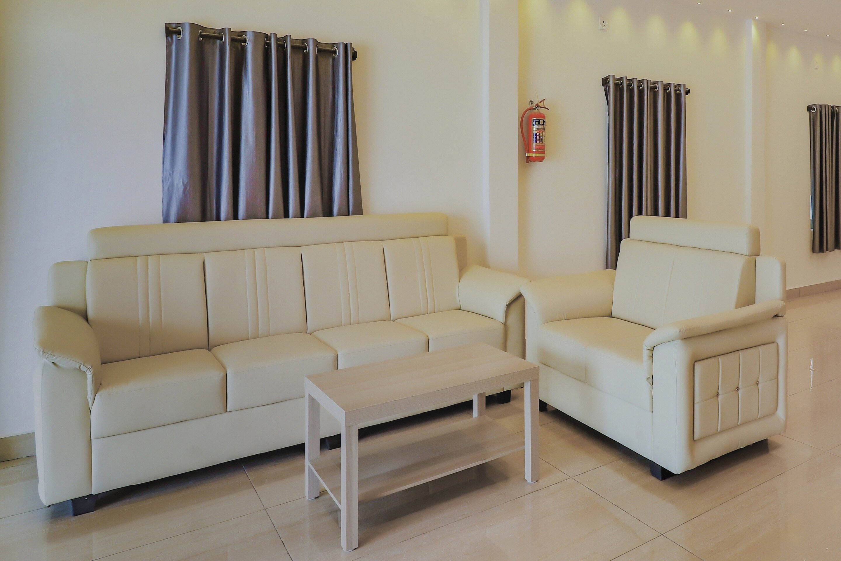 A modern living room with a beige sofa, a matching armchair, and a small coffee table.
