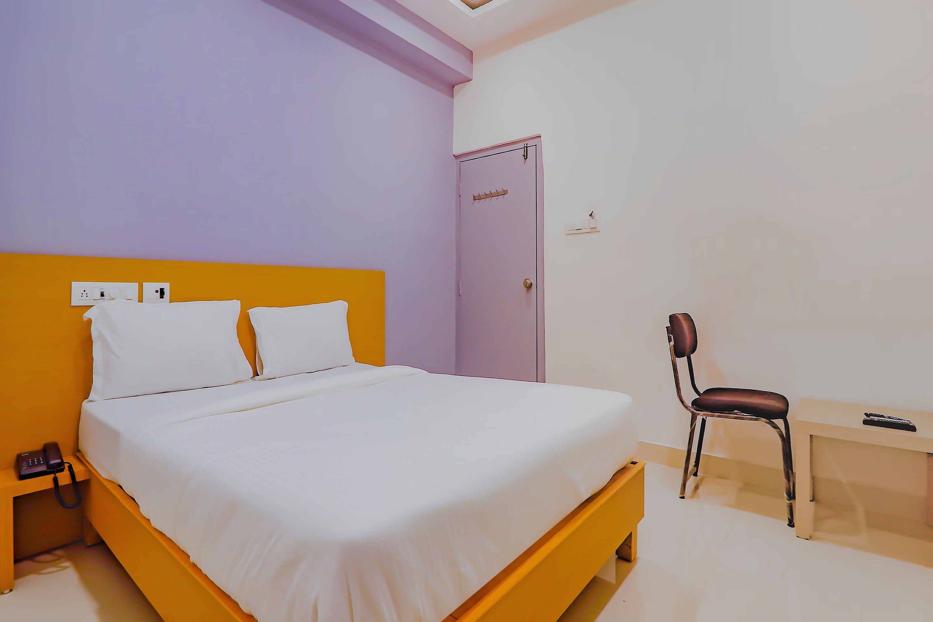 A room with a bed, a desk, a chair, and a wardrobe.