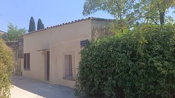 A building with a tiled roof, a paved entrance, and a small window.