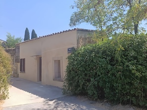 A building with a tiled roof, a paved entrance, and a small window. - Studio 'Bëj-Gànnaar' with Air Conditioning and Garden - Luberon (Saint-Saturnin-lès-Apt)