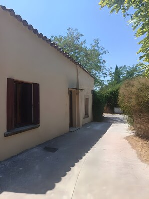 A building with a sloped roof and a narrow pathway leading to the entrance. - Studio 'Bëj-Gànnaar' with Air Conditioning and Garden - Luberon (Saint-Saturnin-lès-Apt)