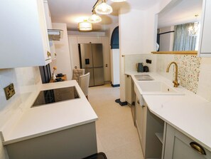 Una cucina moderna con piano cottura integrato, lavello e frigorifero.