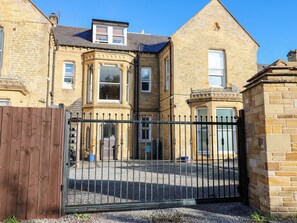 A stone building with a gated entrance and a small driveway. - Bishops Quarter - Flambard (Bishop Auckland)