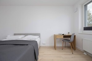 Ein Schlafzimmer mit einem Bett, einem Schreibtisch und einem Stuhl.