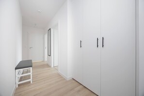 Entrance area with built-in storage, light flooring and a glimpse of the living space. - Warsaw | Grenadierów 41 | Comfortable Apartment | Air Conditioning (Warszawa)