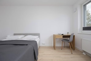 A bedroom with a bed, a desk, and a chair. - Warszawa | Grenadierów 41 | Air Conditioned Studio | Desk (Warszawa)