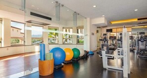 A gym with exercise equipment, large windows, and a view of the outdoors. - 2 bedroom suite with breathtaking oceanfront view! (Cabo San Lucas)