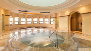 A large indoor pool with a central fountain, surrounded by arched windows and a high ceiling. - 2 bedroom suite with breathtaking oceanfront view! (Cabo San Lucas)