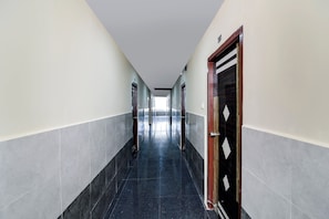 A corridor with doors on both sides, a tiled floor, and a ceiling with a light fixture. - Super Hotel O New Cyber Grand Madhapur (Hyderabad)