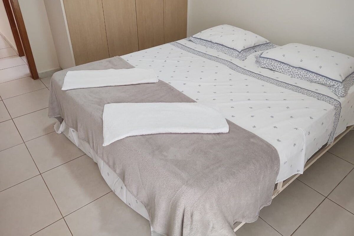 A bedroom with a bed, a wardrobe, and a door.