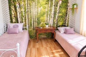 A room with two beds, a wooden table, and a wall mural of trees. - Large holiday apartment in Wisełka (Wisełka)