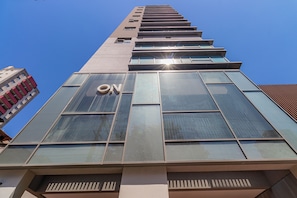 Un bâtiment moderne, avec un grand panneau « ON » bien visible sur la façade, de grandes fenêtres et un ciel bleu clair en arrière-plan.