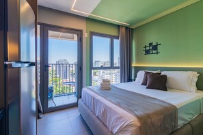 Una habitación de hotel con una cama, un balcón y vistas a la ciudad.