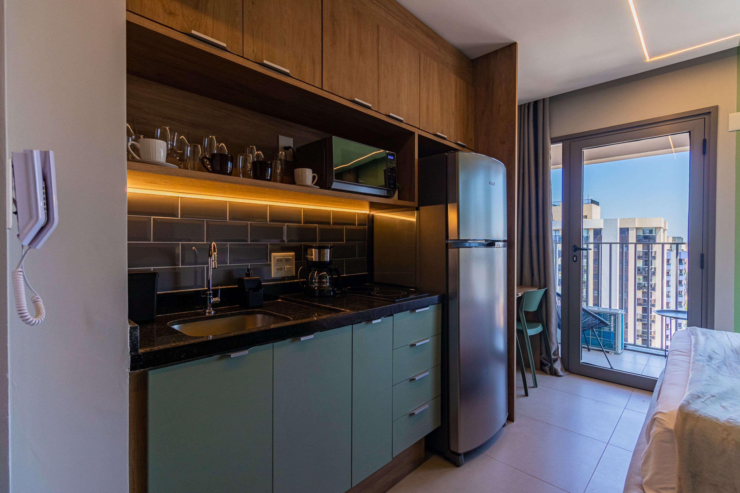 A modern kitchen with a built-in refrigerator, a coffee maker, and a microwave.