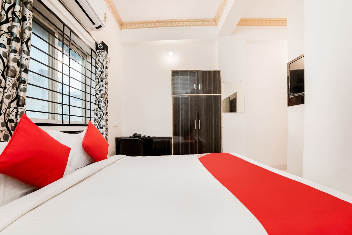 Ein Hotelzimmer mit Bett, Schrank, Schreibtisch und Spiegel.