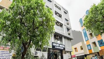 Un edificio de varios pisos con un letrero que dice 'Lucky Hotel & Restaurant' en la planta baja.