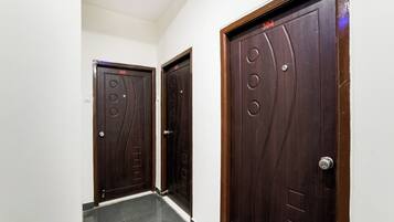 Un pasillo con dos puertas de madera oscura, cada una con un número sobre el pomo.