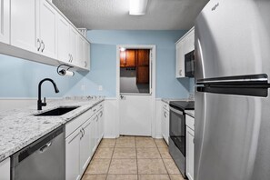 A kitchen with white cabinets, a stainless steel refrigerator, a microwave, a dishwasher, and a granite countertop. - 3-bedroom duplex with 2 living rooms, close to Tiger Town and I85 (Opelika)