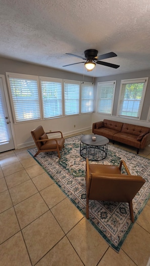A living room with a brown leather sofa, two leather chairs, a coffee table, and a patterned rug. - 3-bedroom duplex with 2 living rooms, close to Tiger Town and I85 (Opelika)