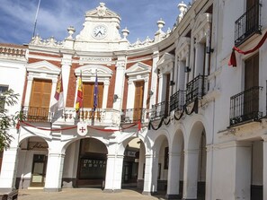 A historic building with a clock tower, a balcony, and flags. - Romantic Holiday Retreat in Manzanares (Manzanares)