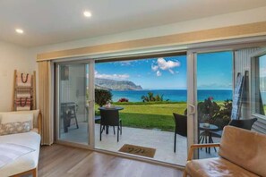 A room with a sliding glass door leading to a balcony with a view of the sea and mountains. - Pali Ke Kua 124 - Bali Hai View, Beautiful Ocn Frt condo (Princeville)
