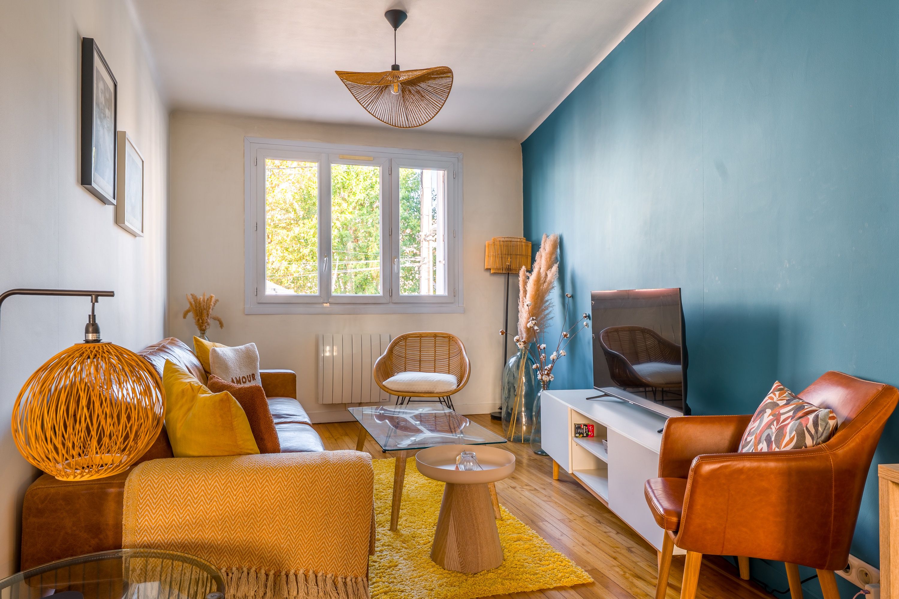 Una sala moderna con un sofá, sillas, una mesa de centro y un televisor.
