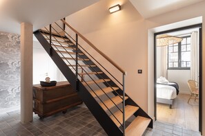 Ein modernes Interieur mit einer Treppe, einem Bett und einem Korbstuhl.