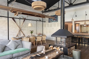 A cozy interior with a dining area, sofa, and a fireplace. - Eden Verde -Lieu d’exception au cœur de Dinard (Dinard)