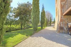A gravel path leading to a stone building with a metal railing. - The Château du Mas, near Lyon (Bessenay)