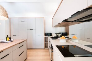 Eine moderne Küche mit weißen Schränken, einer Holz Arbeitsplatte und einem eingebauten Backofen.