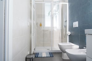 A modern bathroom with a glass shower enclosure, a toilet, and a bidet. - Vrbo Property (Rovigo)