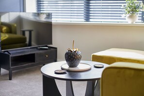 Ein modernes Wohnzimmer mit einem runden Tisch, einer dekorativen Vase und einem Sofa.