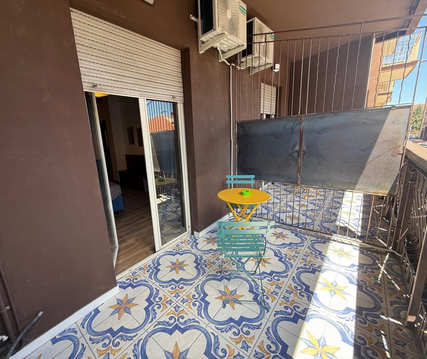 Une pièce dotée d’un sol carrelé, d’une table avec des chaises, d’une porte coulissante et d’un appareil de climatisation.