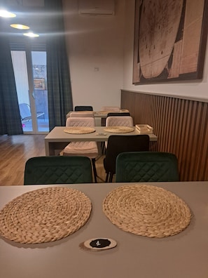 Un coin repas avec une table dressée pour quatre personnes, agrémenté de sets de table en fibres tressées et d’une seule assiette.