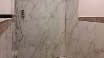 Ein Badezimmer mit Dusche, Toilette und Bidet.