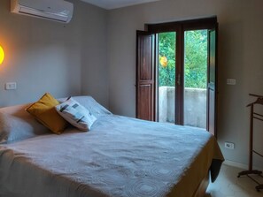 A bedroom with a bed, a window, and an air conditioning unit. - Casa Cecilia - Detached Home with Ocean View, Garden, and Terrace in Maratea (Maratea)