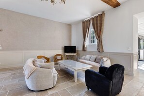 A living room with a sofa set, a coffee table, and a television.