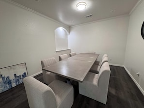 Ein Konferenzraum mit einem großen Tisch, sechs Stühlen, einer Whiteboard-Tafel und einem Bild an der Wand.