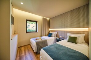 A hotel room with two beds, a window with a view, a bedside table, and a wall-mounted TV. - Villas Carreiro - Villa Musgo | Vineyard Escape with Private Pool, Porto (Maureles)