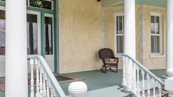 A porch with white columns, a ceiling fan, and a number '105' above a door.