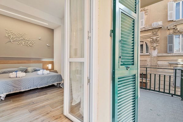 A hotel room with a bed, a nightstand, and a wall-mounted decoration.