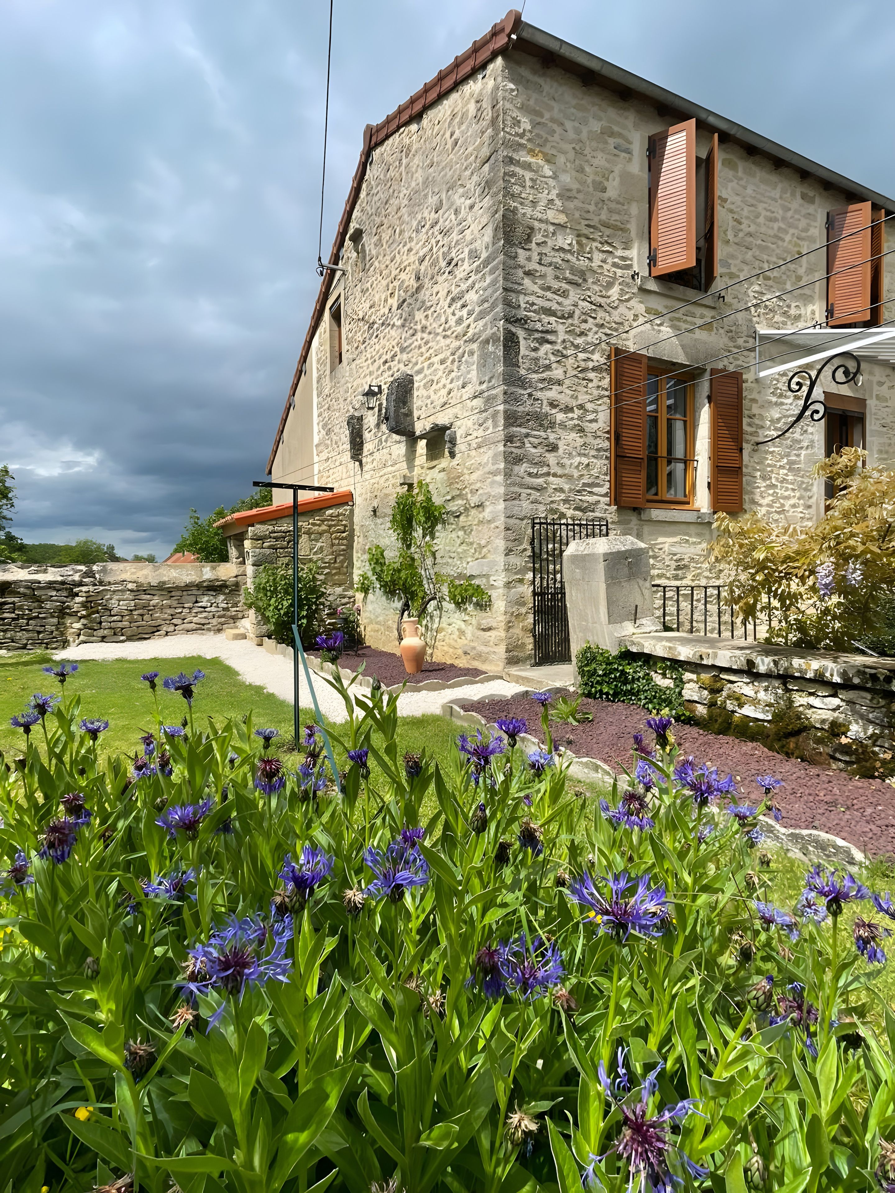 A stone building with a garden in front.