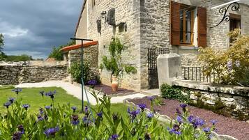 A stone building with a garden in front.