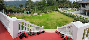 Una escalera que conduce a un césped verde con vistas a un paisaje montañoso.