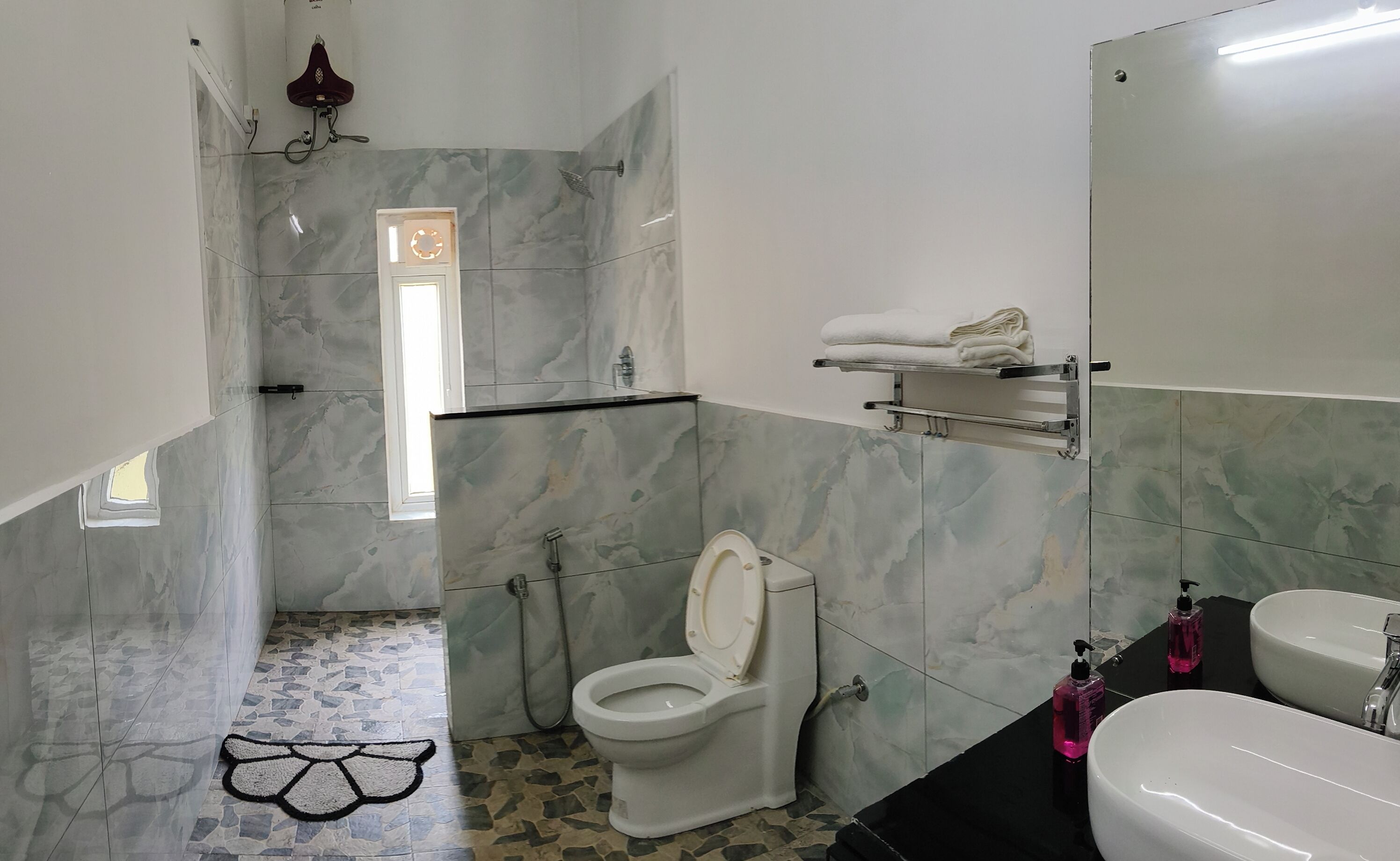 A bathroom with a toilet, sink, and shower area.