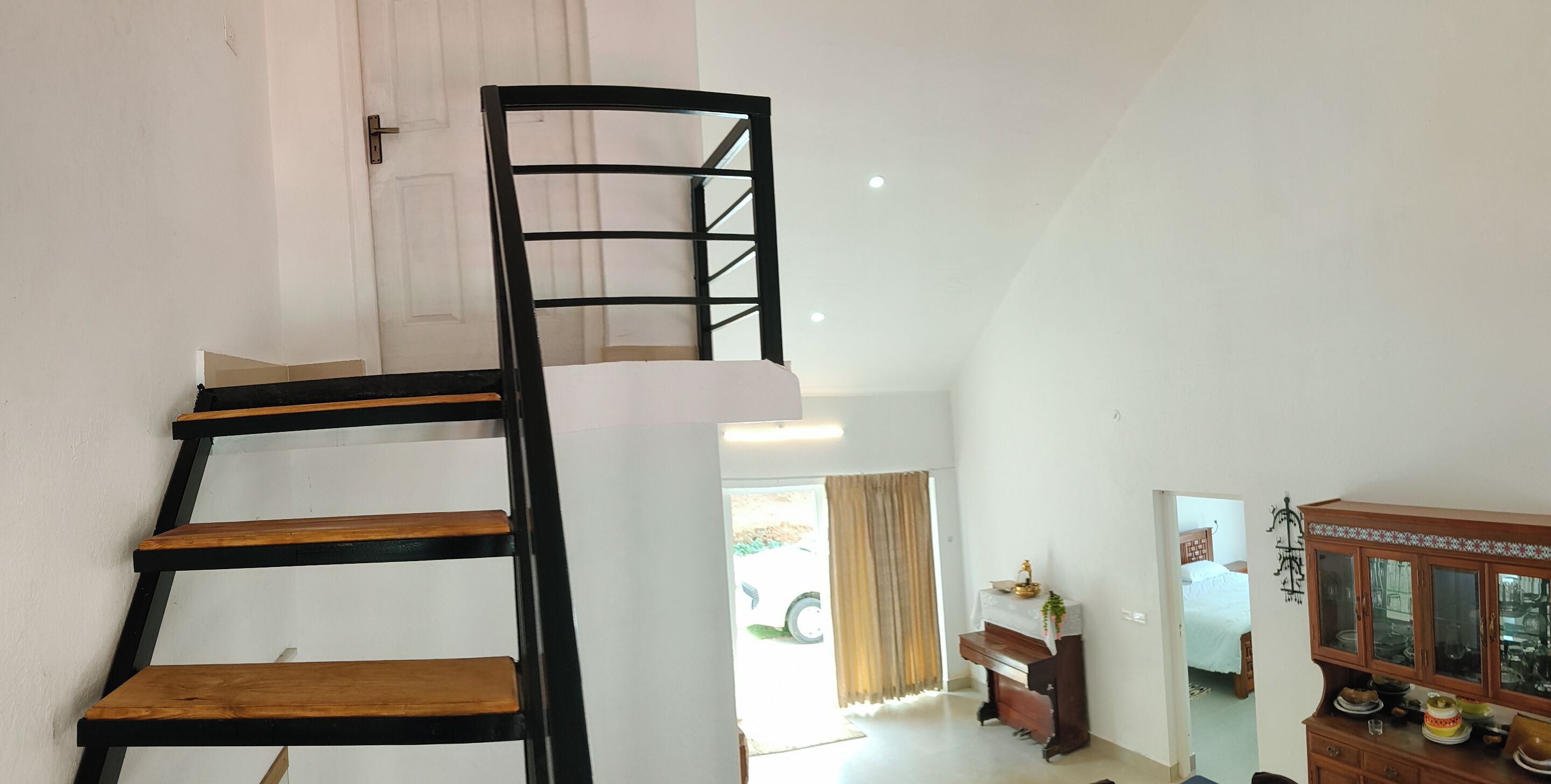 A staircase with wooden steps and black railings leading to an upper floor.