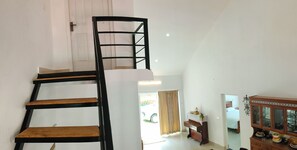 A staircase with wooden steps and black railings leading to an upper floor. - Mighas Vila  (Full Bungalow with three Bedroom) (Yedapalli, Coonoor.)