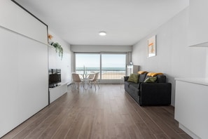 A modern apartment with a balcony, a dining area, and a living space. - Blankenberge Beachfront Stay (Blankenberge)