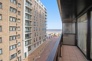 A high-rise building with multiple balconies overlooking a beach with beach equipment. - Hill Apartment With Park Views (Blankenberge)