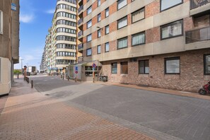 A multi-story building with a mix of brick and concrete facades, a visible entrance, and a clear sky. - Hill Apartment With Park Views (Blankenberge)